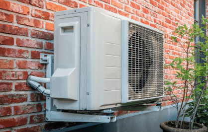 Heat pump on home wall in the garden
